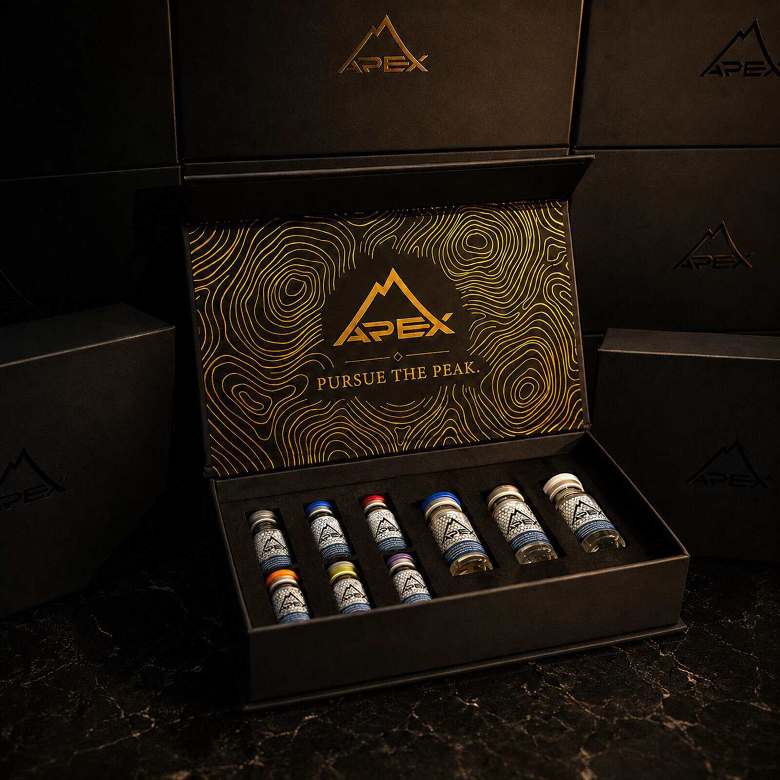 Apex Laboratory research peptide kit in a premium black box with colored-cap vials and gold Pursue the Peak branding